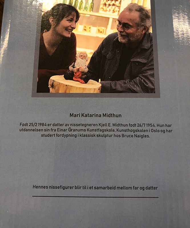 Midthun-nisse stående med lua i handa